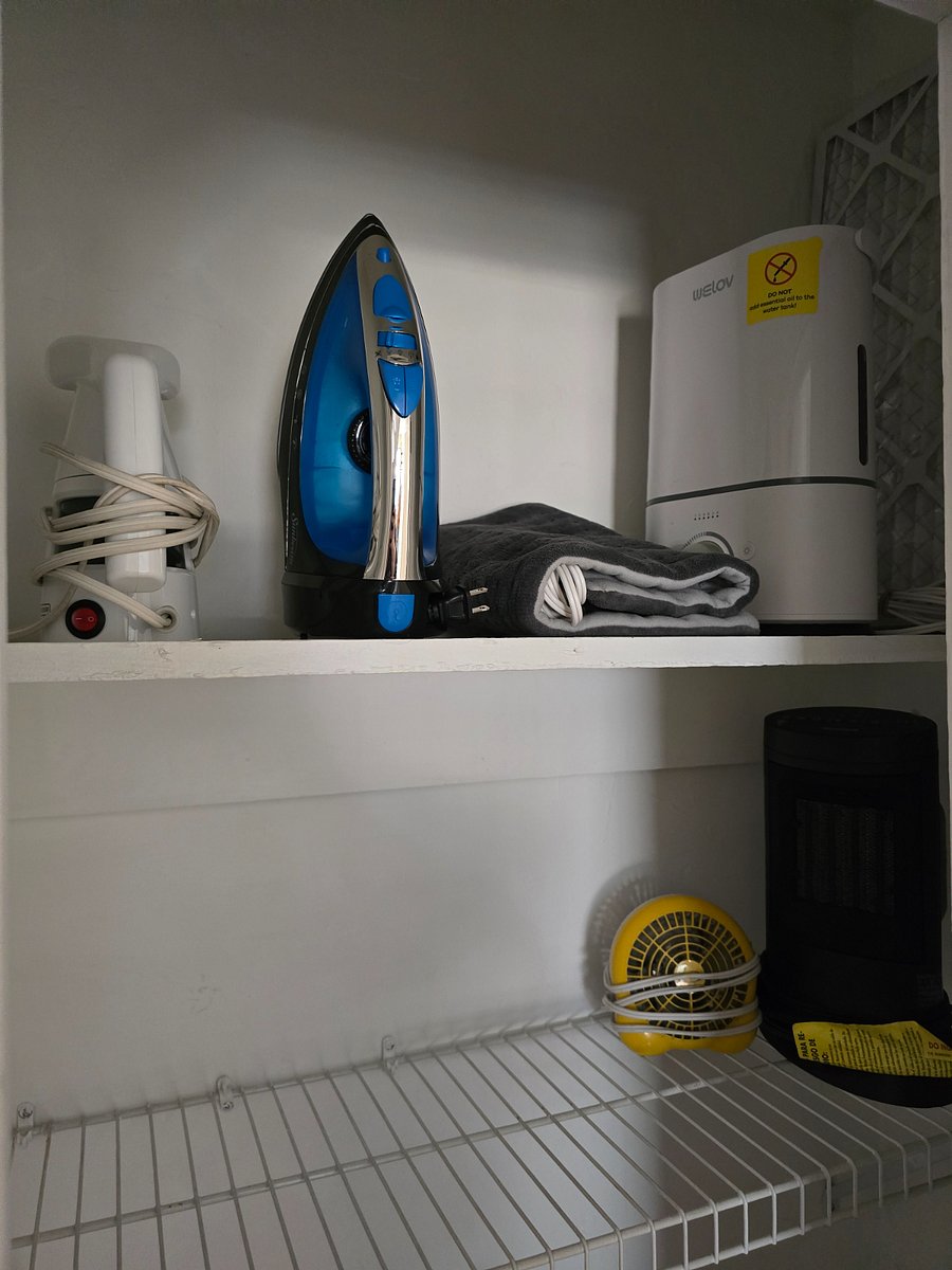 2nd bedroom - first closet with iron, steamer, heating pad, fan, small safe, and other items