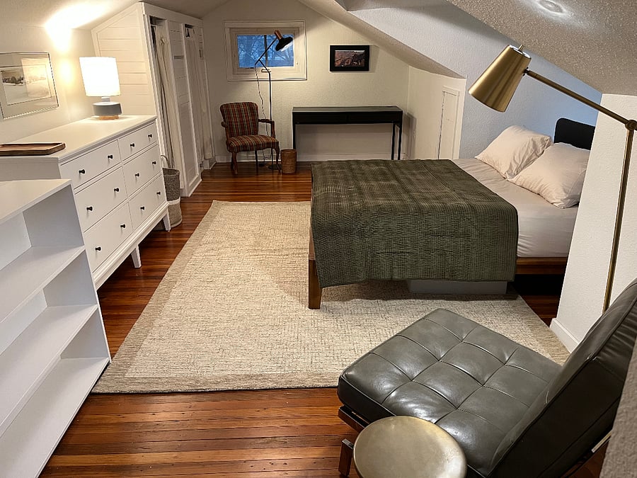 Large primary bedroom with queen bed, desk and sitting area.