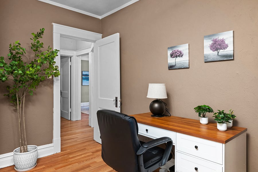 Separate home office with full-size desk and comfortable chair ideal for charting, remote work, or studying.