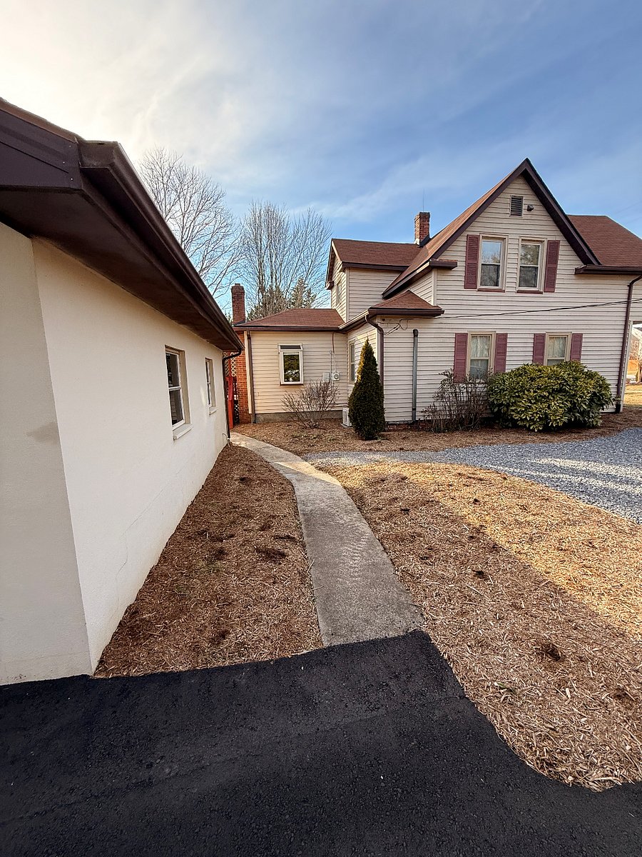 Side entrance of home with parking. An automatic post light at porch steps comes on at dusk to dawn.