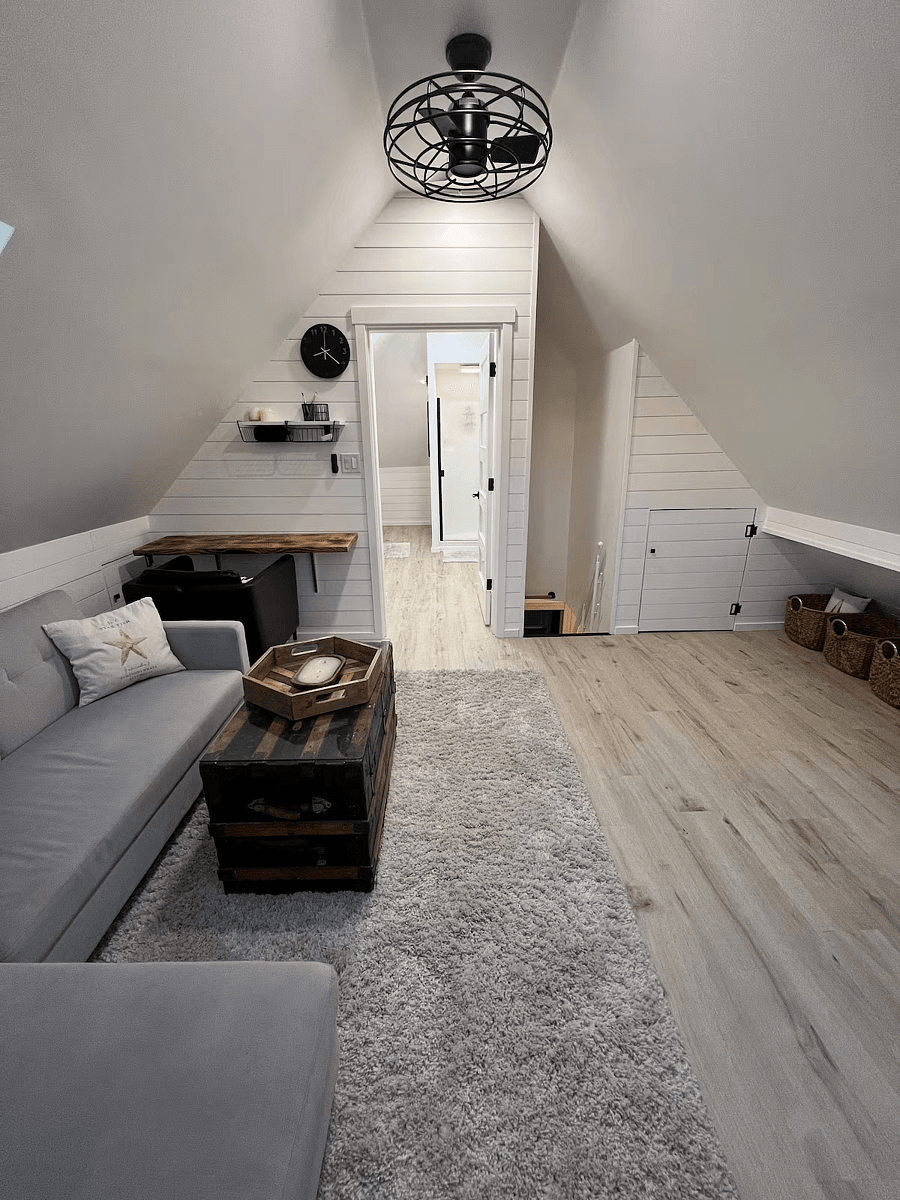 Attic Living Room with Smart TV, VSeeBox, and Storage.