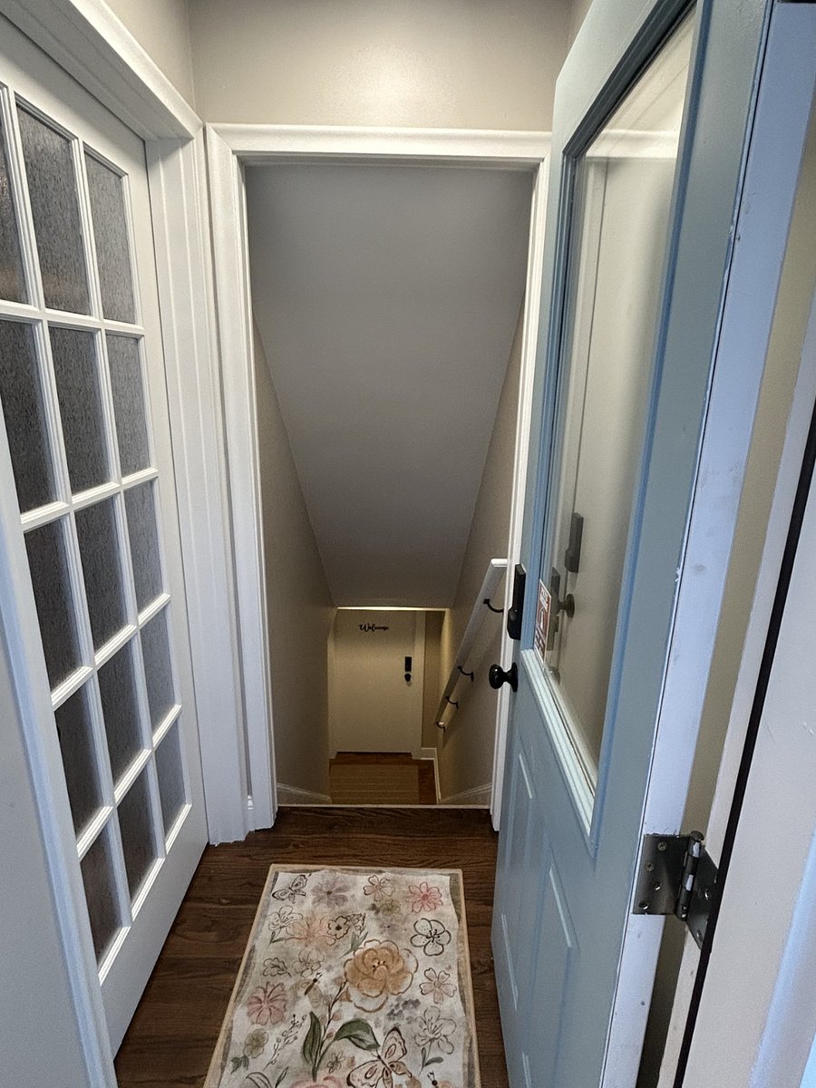 View from entry area to the lower landing where the guest suite entry is located. The back door is shared by the main floor and the lower level guest suite, but guests and the homeowner have separate living spaces.