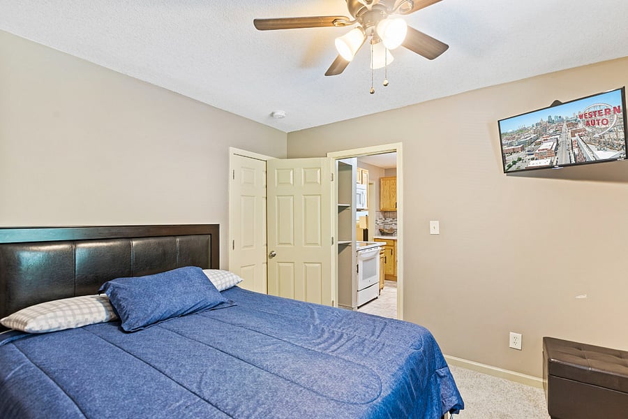 Bright and comfortable bedroom featuring a Smart TV and ample dresser space for extended stays