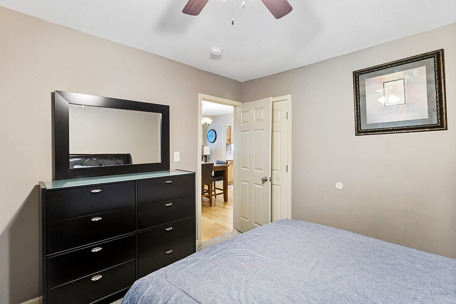 Well-appointed bedroom with comfortable bed, Smart TV, and dresser for storage
