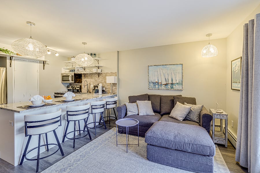 Living room and kitchen with large peninsula and 4 low bar stools.