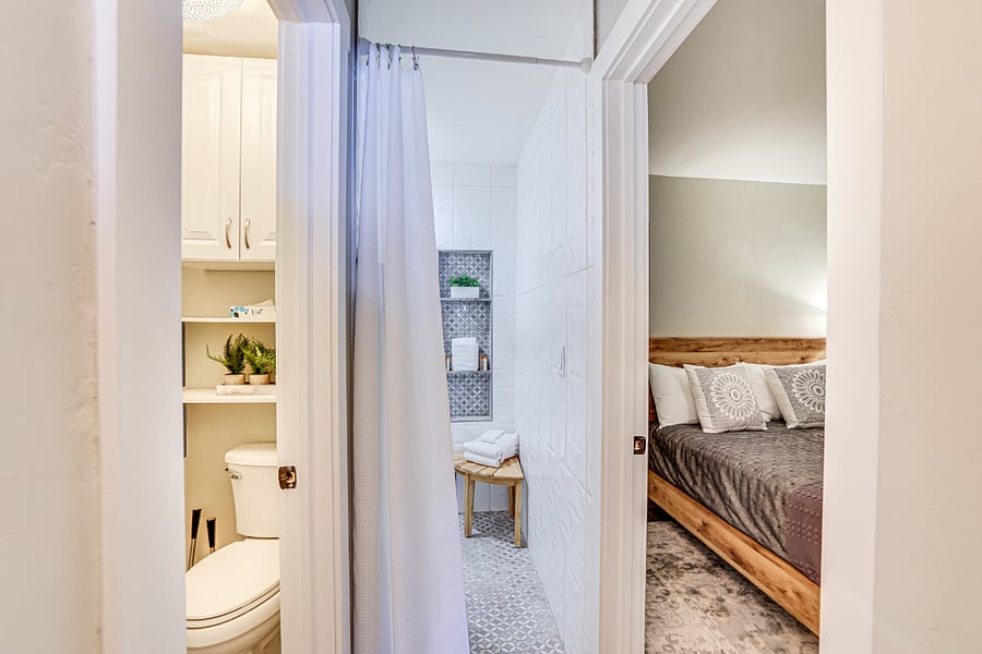 View of private toilet room, shower and bedroom from the hallway.