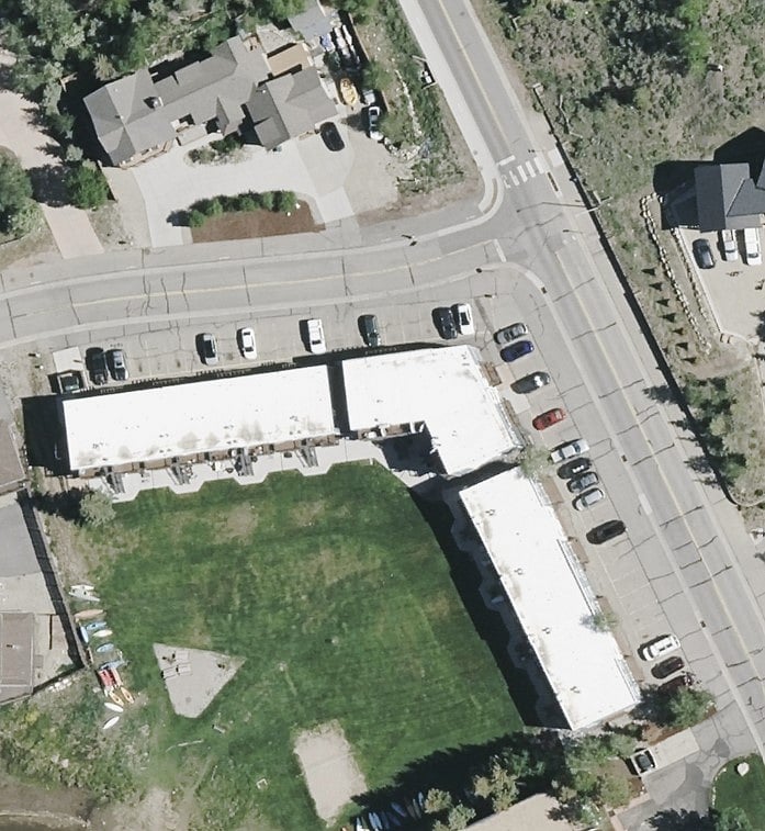 Birds-eye view of condo complex and "L-shaped" parking lot around the complex.