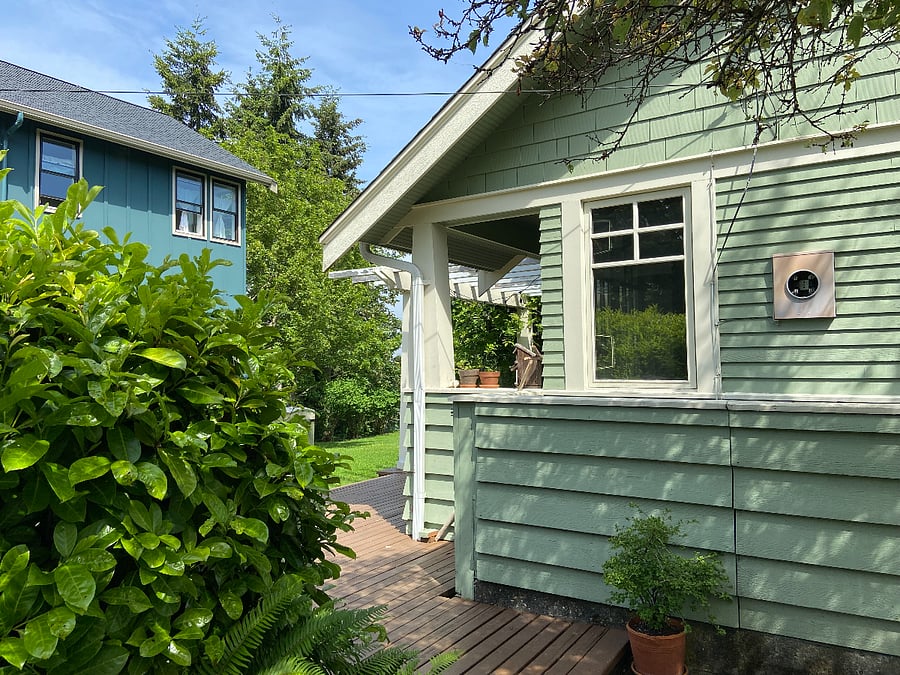 View of the house from the back entrance to the larger green house on the property.