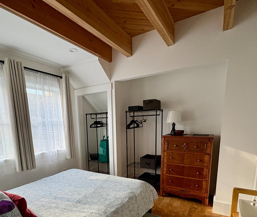 Bedroom has dresser and two wardrobes for clothes.