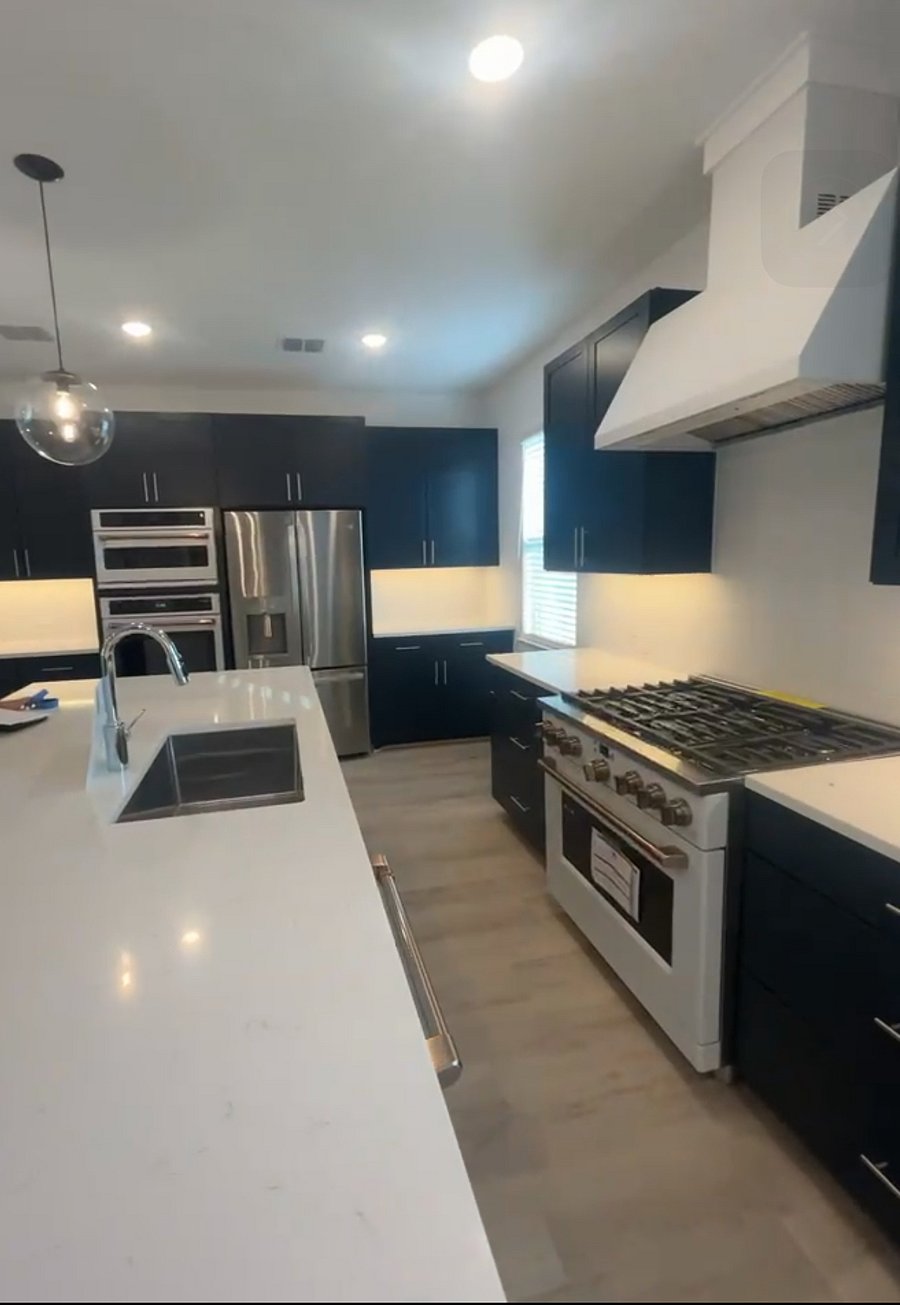 Modern shared kitchen complete with professional stove, wall oven and a quartz countertop