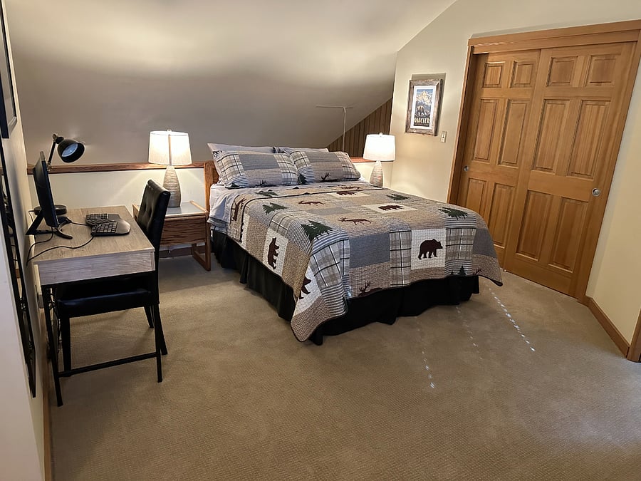 Upstairs loft bedroom with desk and monitor.