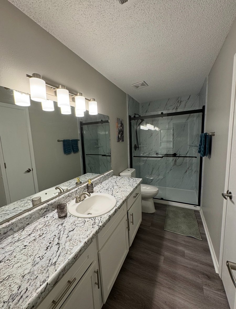Largest bathroom newly renovated w/ walk in shower with grab bars, quality fixtures and sliding glass doors