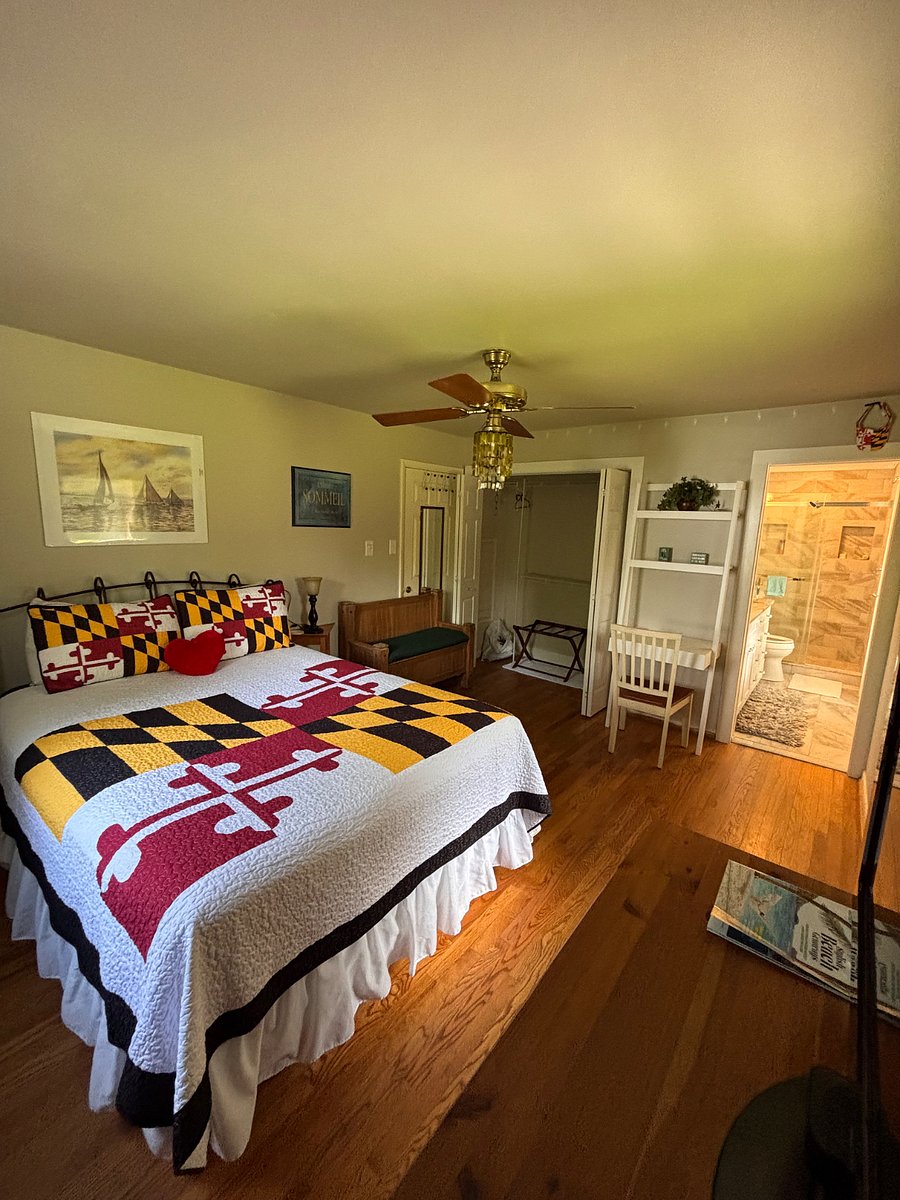This photo shows the queen size bed, and the double closet with folding doors, the wall desk with drawer and shelves. The light and ceiling fan . Also shows the pocket door entrance to the master bath