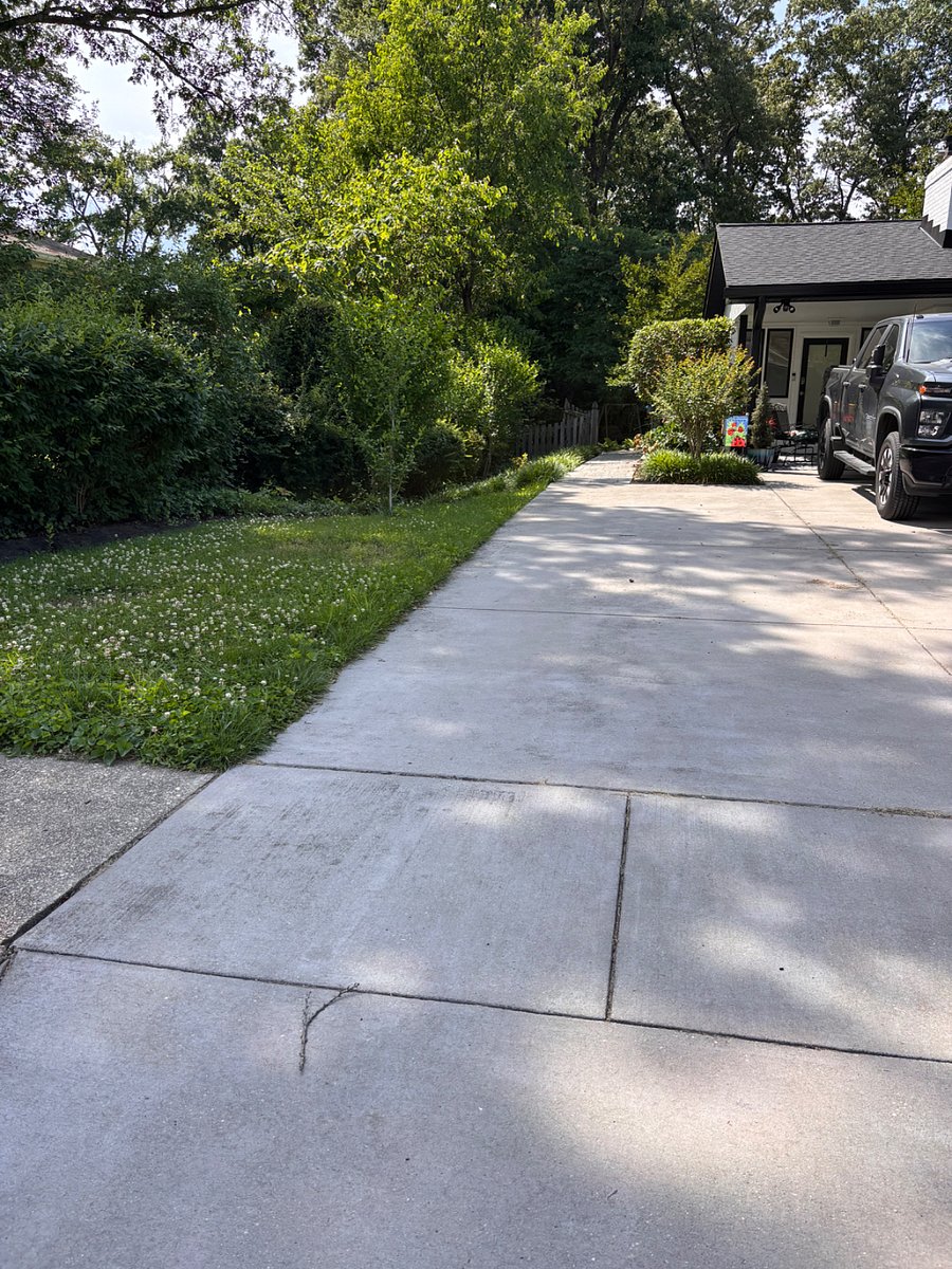 This photo shows the driveway with one very large space for a single vehicle with a path leading to the back patio and the unit entrance. The carport space is private to the owner and not available to the occupant.