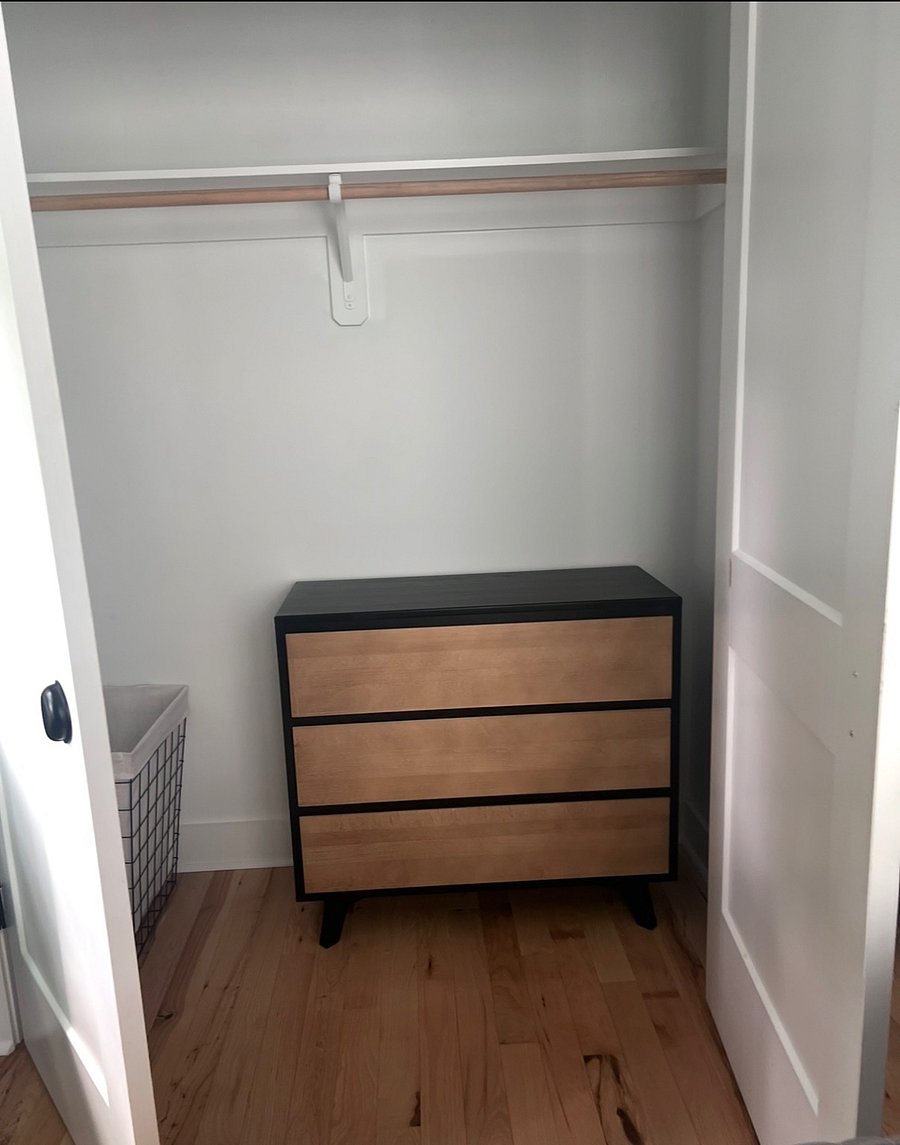 Chest of drawers available for folded clothing in closet of bedroom