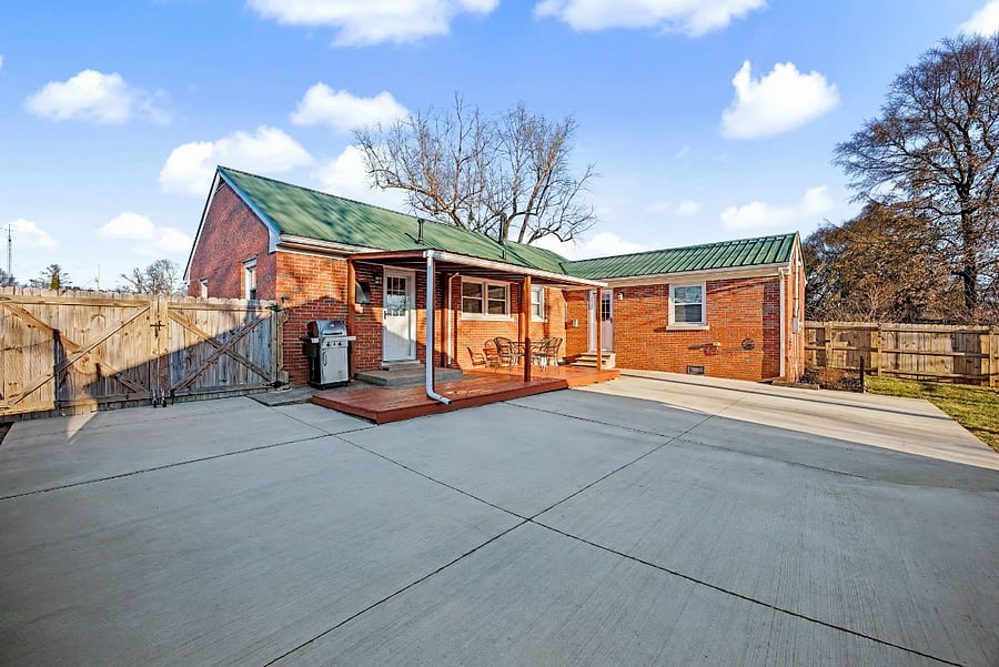Fenced-in backyard with covered back deck, patio & propane grill