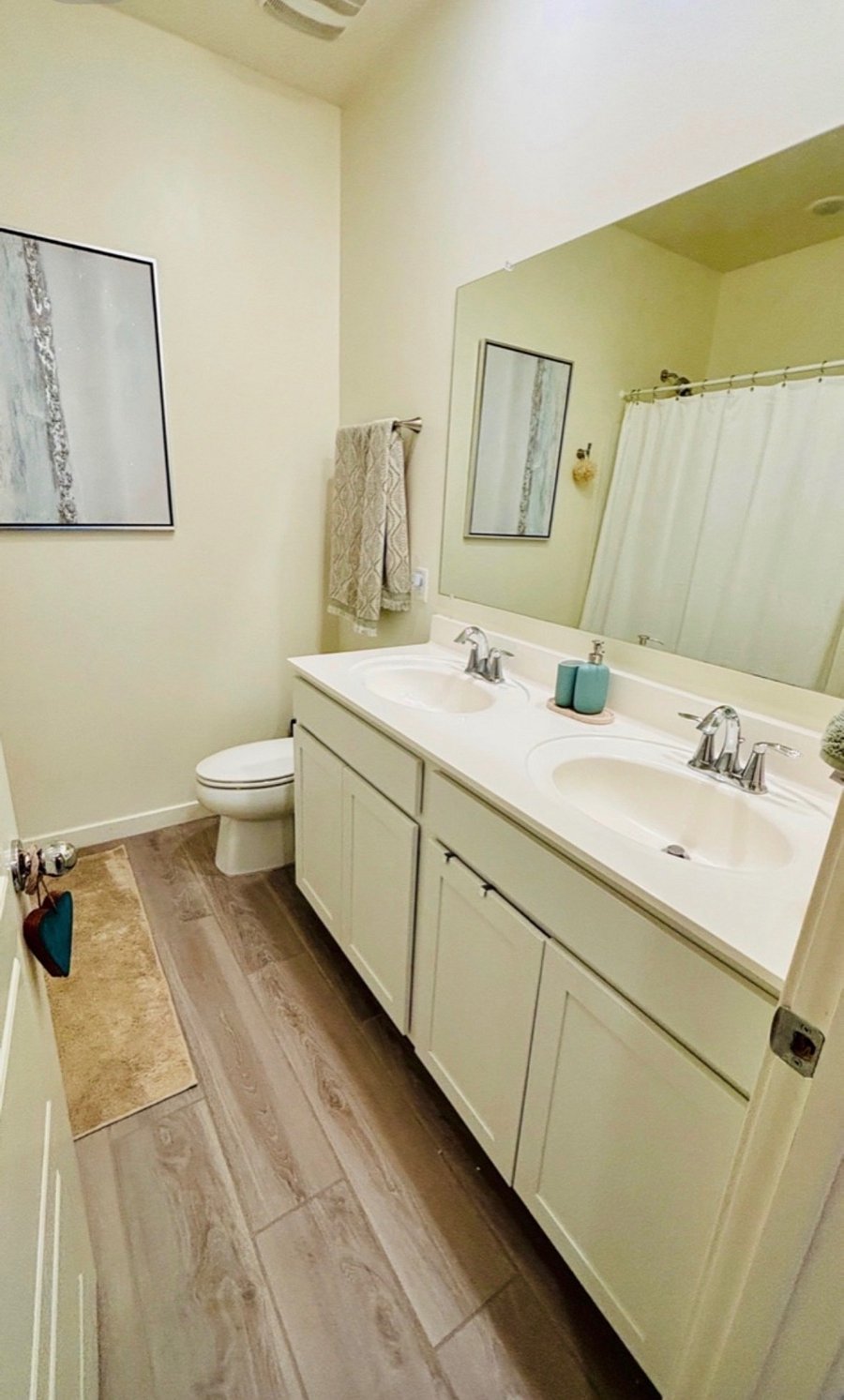 Private bathroom with double vanity and shower/tub combo adjacent to the guest suite. Starter toiletries and basic household supplies provided.