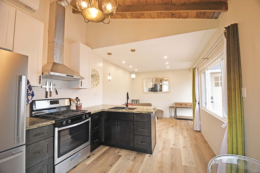 Full stove/range/oven, and full fridge/freezer. Open plan to living room. Plenty of natural light and windows.