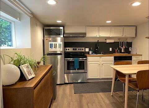 Entryway looking into kitchen and dining area. Large cabinets and storage.