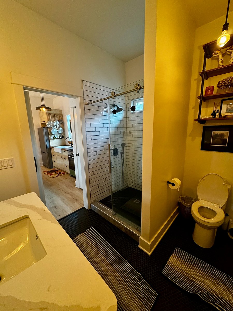 Spa-like bathroom with a huge walk-in shower and endless on-demand hot wateryoull never run out. Enjoy the rain shower head with strong water pressure, a cozy built-in bench for relaxing with the handheld sprayer, and beautiful natural light from the valance window. Thoughtfully designed lighting by a local Portland-based renovation company completes the space.