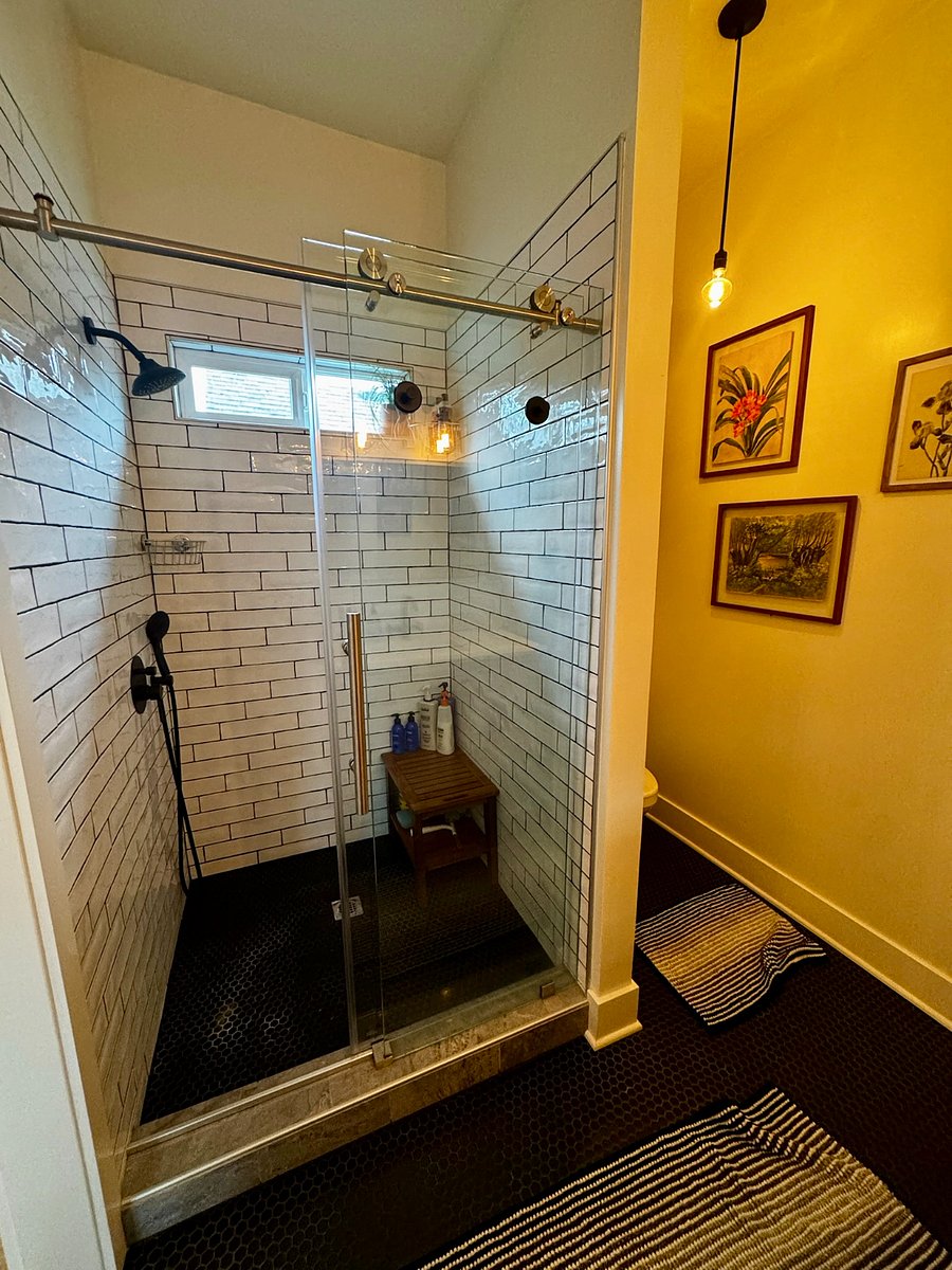 Spa-like bathroom with a huge walk-in shower and endless on-demand hot wateryoull never run out. Enjoy the rain shower head with strong water pressure, a cozy built-in bench for relaxing with the handheld sprayer, and beautiful natural light from the valance window. Thoughtfully designed lighting by a local Portland-based renovation company completes the space.