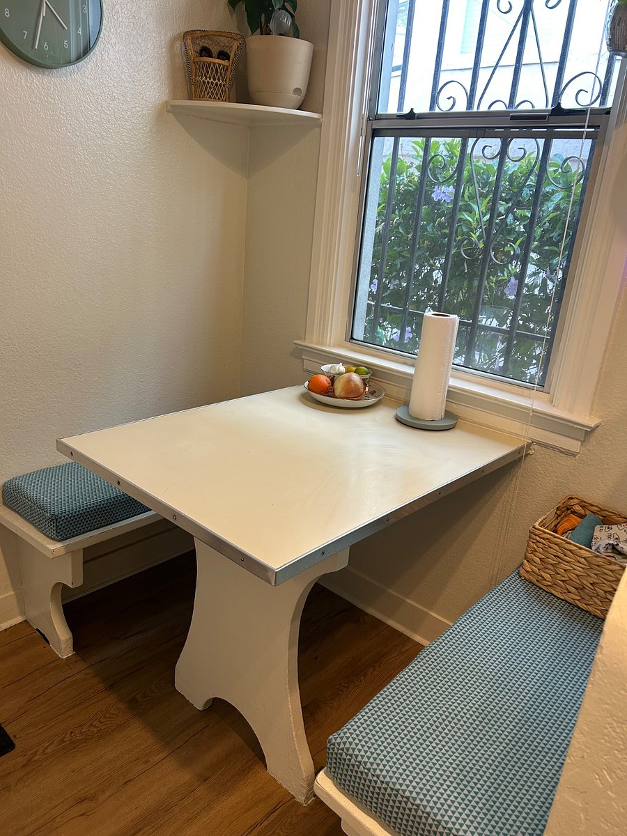 Breakfast nook in the kitchen with custom cushions, behind the nook is a door that leads out to the back patio area and lets in midday sunshine.