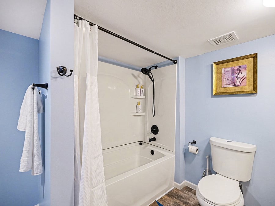 A. modern full bathroom with a bathtub and a shower head.