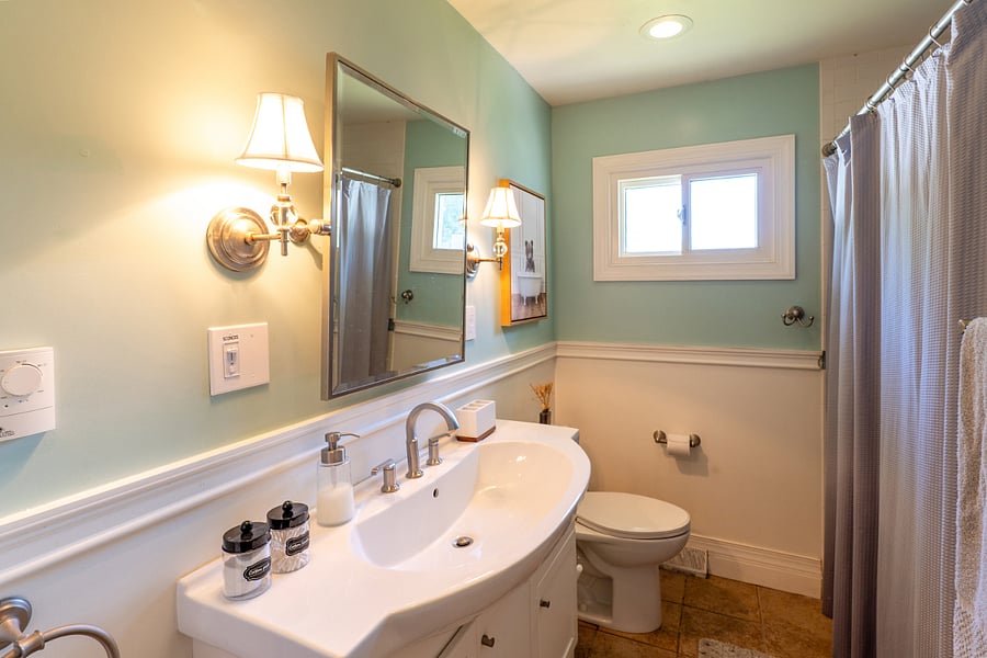 Main bathroom features a tub and shower with wand for easy reach and clean. Plenty of shelves to keep everyone's toiletries and essentials in the bathroom.