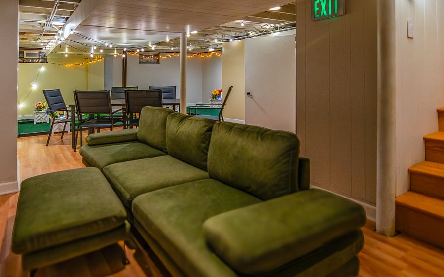 Basement features a sofa and table. Perfect for binge-watching shows, playing games or challenging each other to some mini golf!