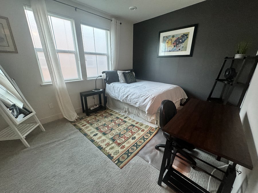 Bedroom with full size bed on the second floor and a workspace.