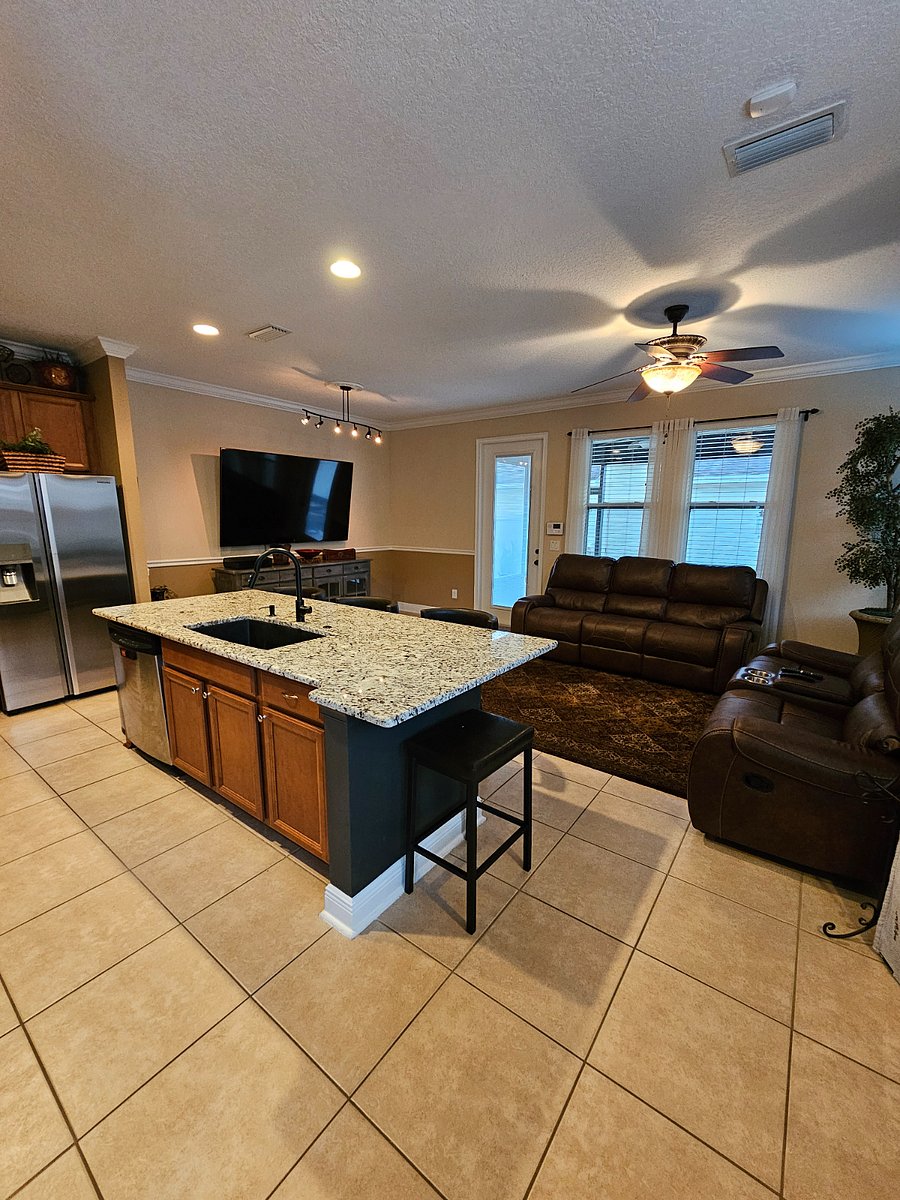 Kitchen Island, LR, backdoor to screened in porch, open courtyard with grill that leads to the garage.