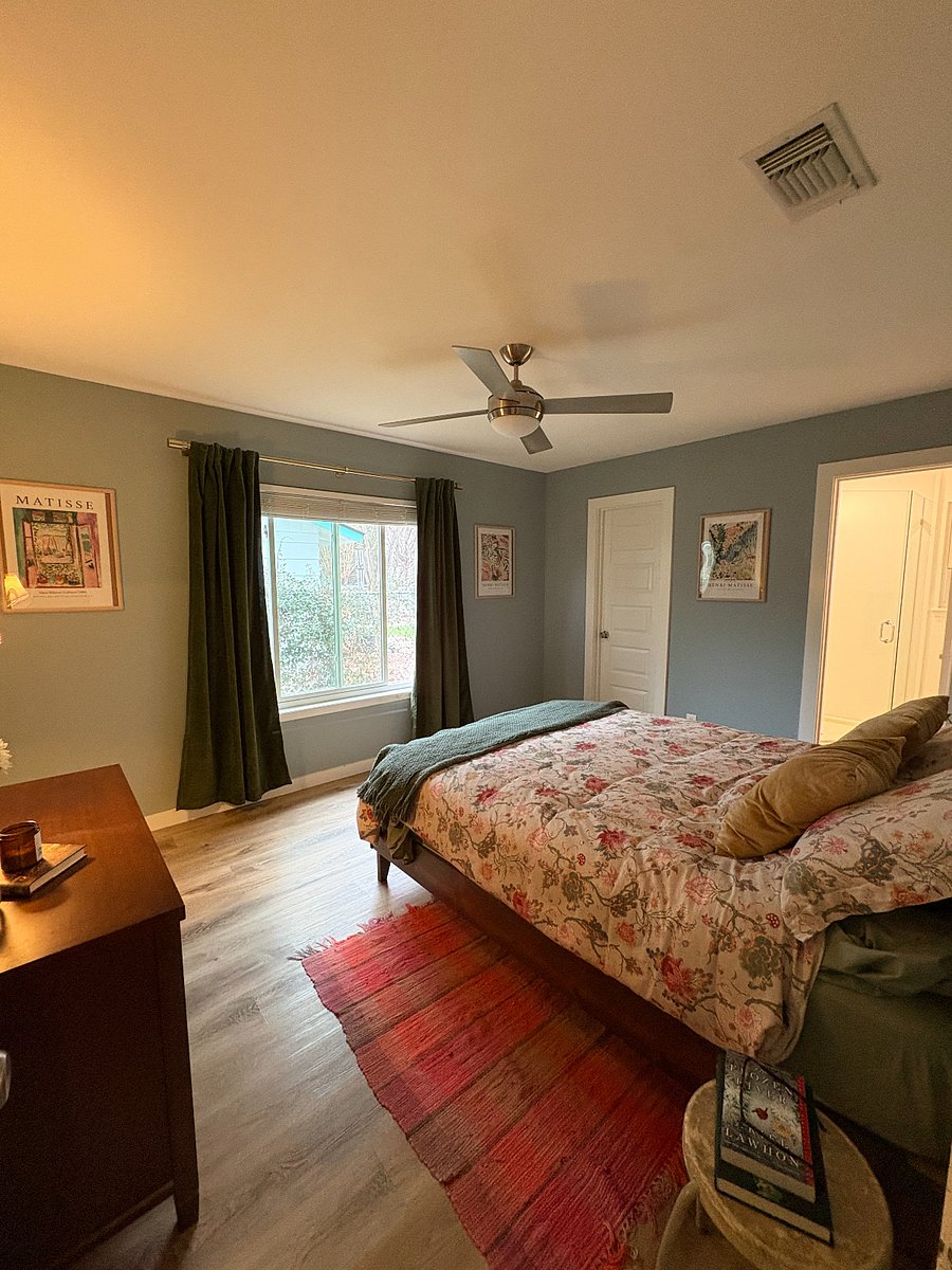 Bedroom with Queen-size bed, blackout curtains, bathroom with shower, and walk-in closet (pictured with door closed).