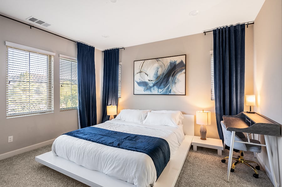 Spacious primary bedroom with king bed and blackout curtains