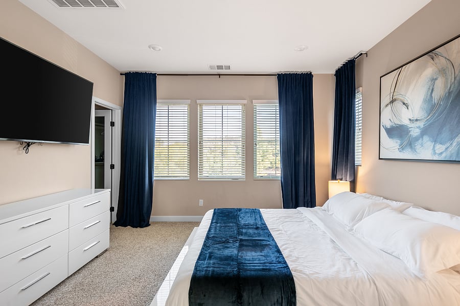 Spacious primary bedroom with king bed and blackout curtains