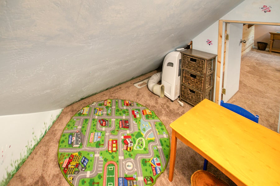 Kids playroom opens to hallway near bathroom in upstairs loft