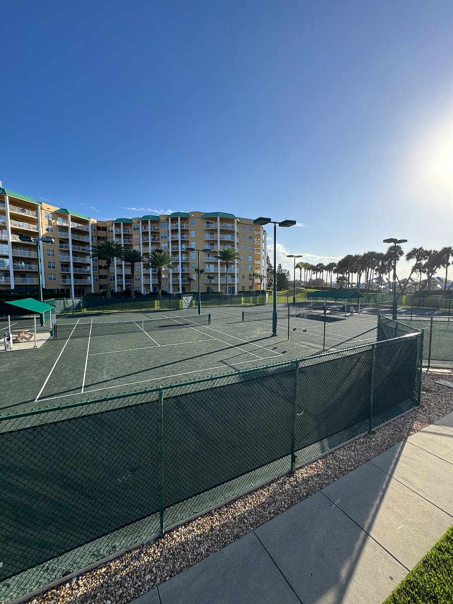 Beautiful onsite Har-Tru clay tennis courts with observation deck and tables and umbrellas.