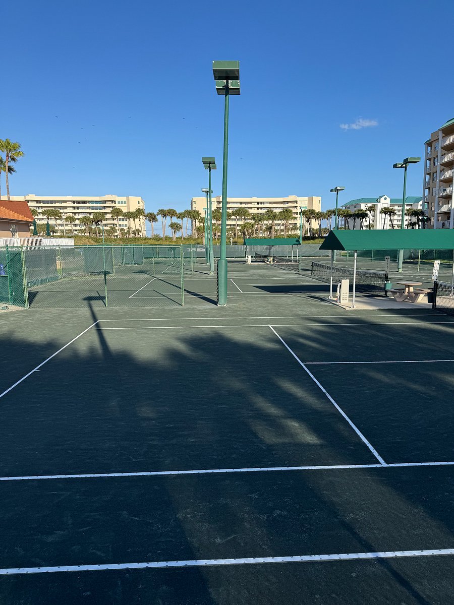 Beautiful onsite Har-Tru clay tennis courts with observation deck and tables and umbrellas.
