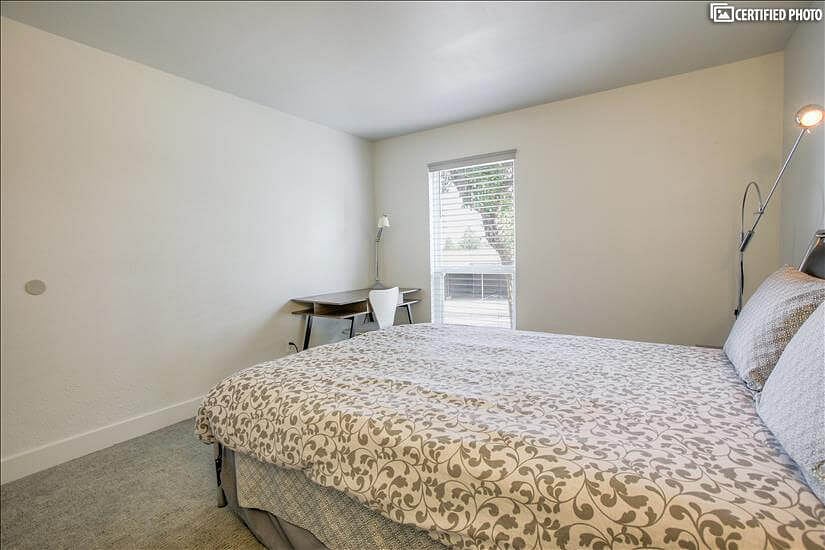 Guest bedroom with desk, chair and lamp for remote work and study