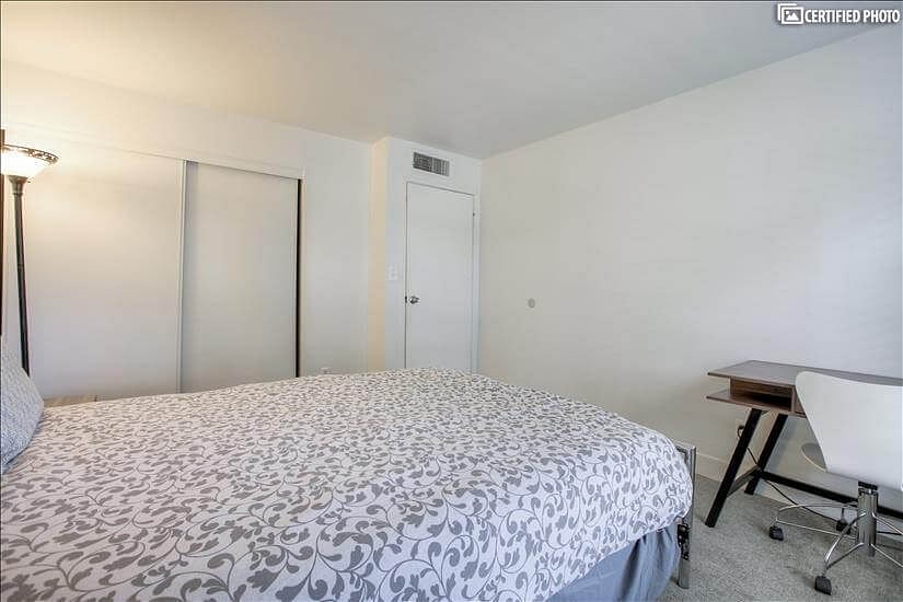 Guest bedroom with desk, chair and lamp for remote work and study