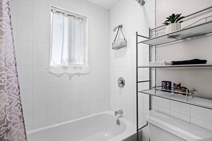 Privacy window curtain, shower caddy, body wash, shampoo, conditioner, and toilet paper are provided for added comfort.