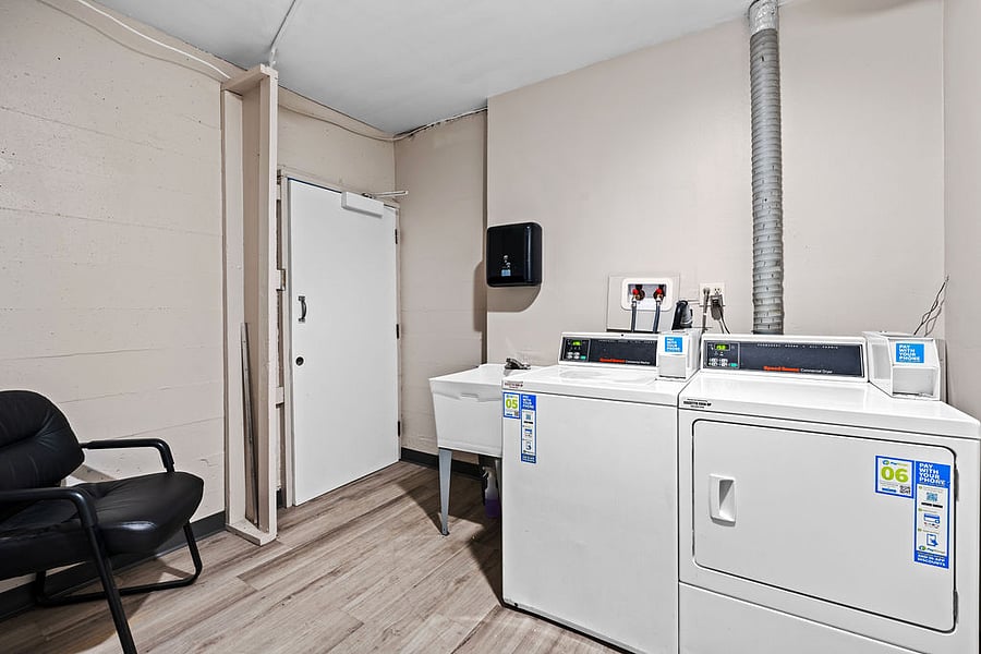 On-site laundry facilities feature a QR code commercial washer and dryer, plus a wash sink, located on the buildings lower level.