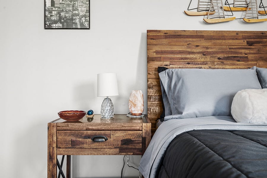 A welcoming side table featuring a key dish, Chinese Baoding Balls for you to help relax, a salt lamp to promote great sleep, and a Bible for a cozy touch.