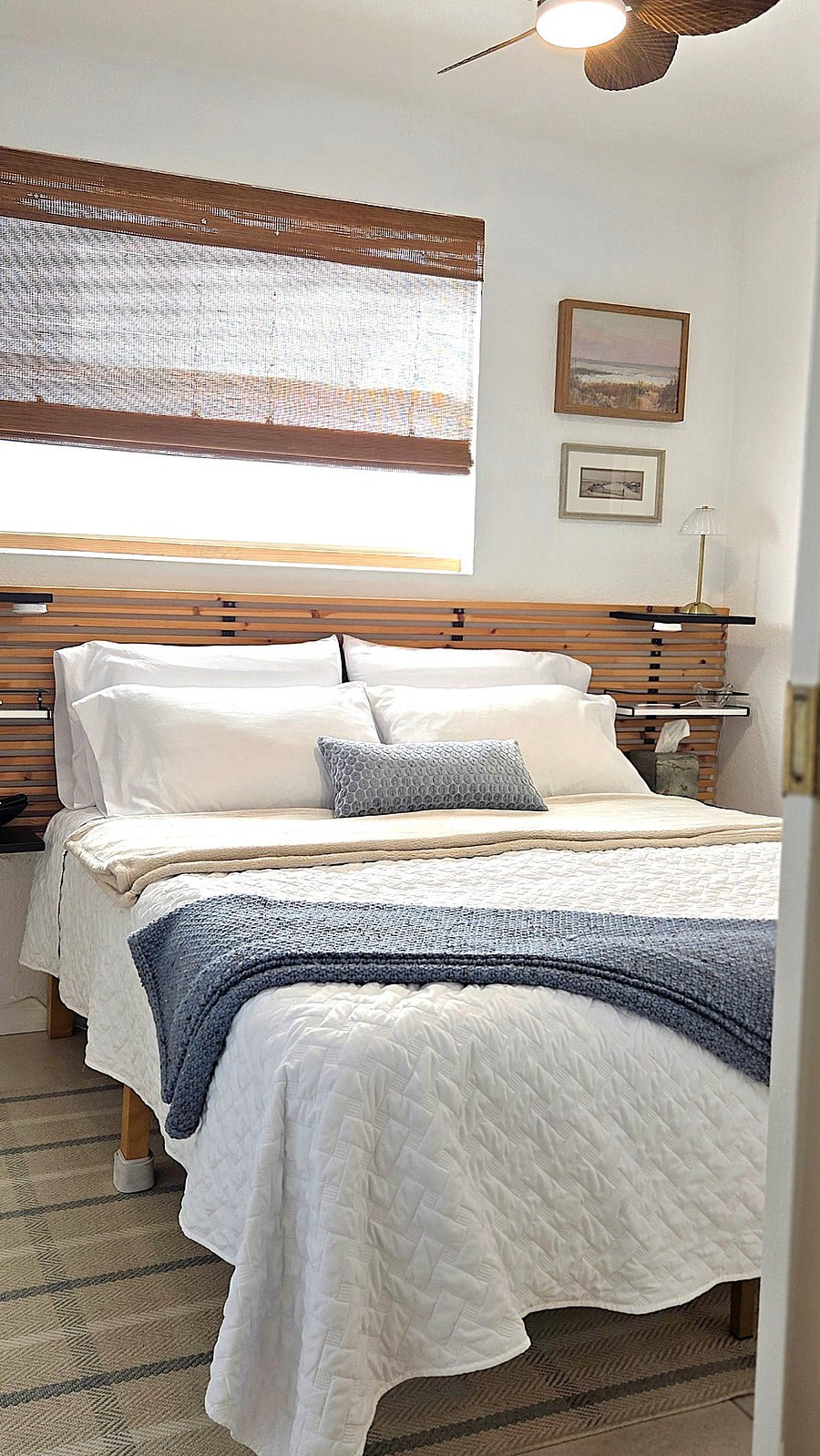 Enter the serene bedroom featuring a comfortable queen bed and soft coastal touches