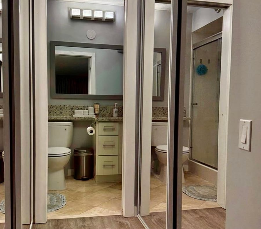 Mirrored closet doors in primary bathroom and bedroom.