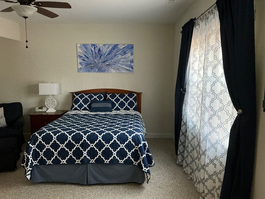 Bedroom with large window and black-out curtains