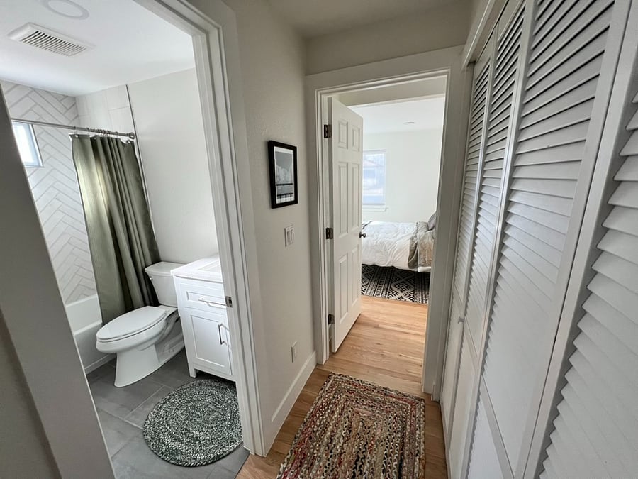 Looking down the hallway to the second bedroom, hallway bathroom on left