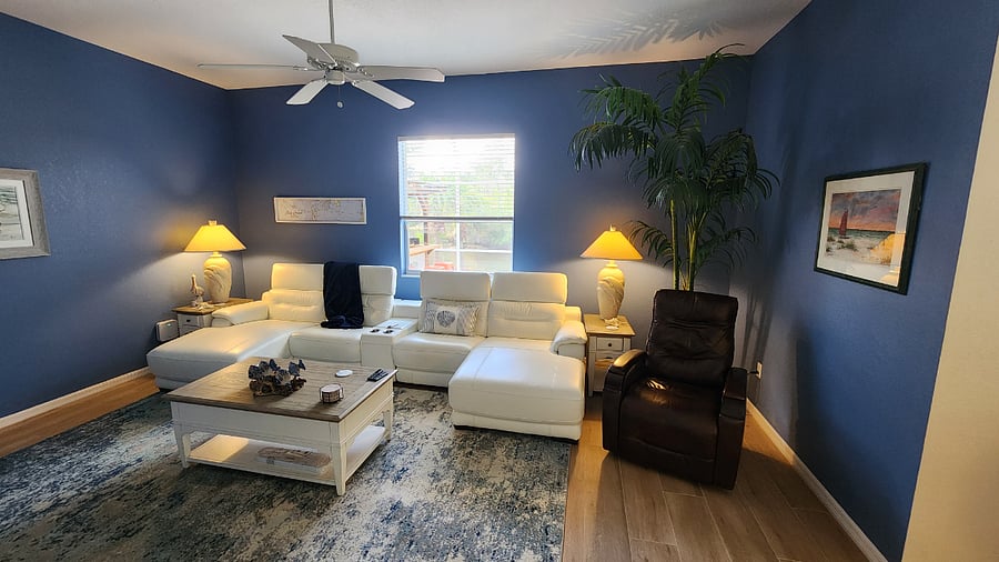 Living Room with new 75" Smart TV, Power Reclining Italian Leather Sectional and Brown Leather Power Reclinging Swivel Rocking Chair.