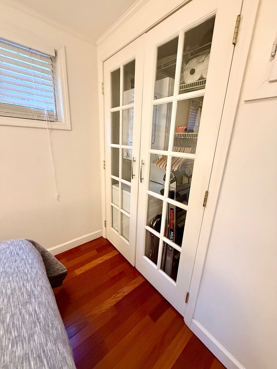 Secondary bedroom with stacked washer/dryer unit in closet