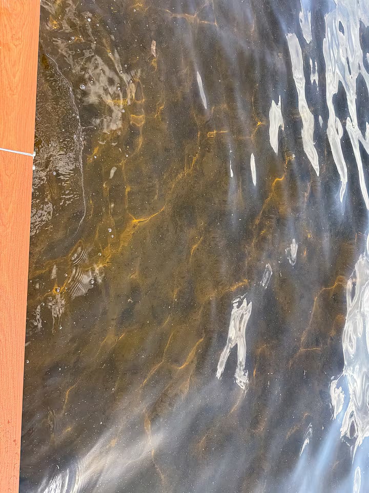 Sandy bottom off the end of the dock. Water is approximately 3.5'-4' feet deep off the end of the dock.
