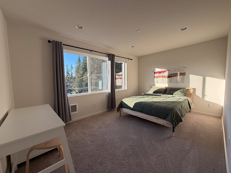 Master bedroom equipped with desk and queen bed